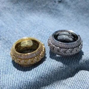 Gold and silver Cuban spinner rings displayed on denim