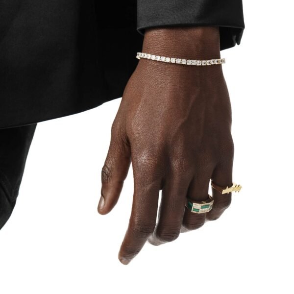 Tennis bracelet and gold rings styled against black formal wear