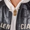 Gold plated dog tag with crystal "ALM" text, styled with white hoodie and leather jacket