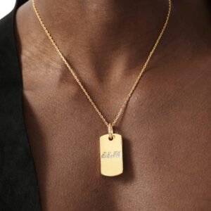 Gold plated dog tag pendant with diamond text logo worn with black blazer