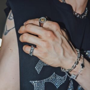 White gold diamond gridlock chain bracelet styled with matching rings against rhinestone-detailed black clothing
