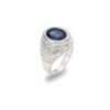 Angled view of white gold ring featuring oval sapphire center, double diamond halo, and engraved band against white background