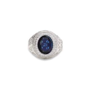 White gold ring with oval blue sapphire center, double diamond halo, and engraved band detail on white background