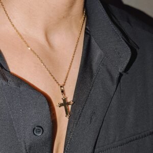 Gold plated polished cross pendant reverse side on fine chain with black shirt