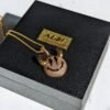 Gold-plated crystal devil smiley pendant on black box with brand tag