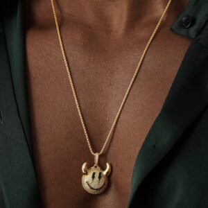 Gold zirconia devil smiley pendant necklace worn with dark green silk shirt