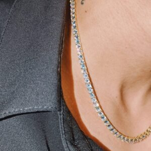 Yellow gold and diamond tennis necklace worn with black shirt, close-up detail Filename: diamond-tennis-necklace-detail