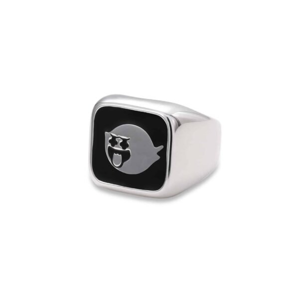 Detailed view of silver signet ring with black enamel ghost design on white background