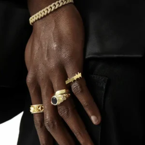 Multiple gold rings paired with curb chain bracelet on dark skin tone