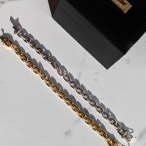 Gold and silver gridlock bracelets with marble backdrop and black box