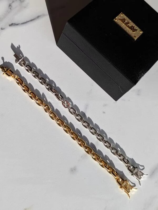 Gold and silver gridlock bracelets with marble backdrop and black box