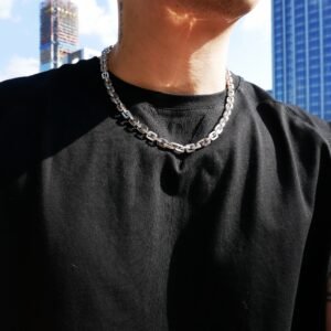 White gold gridlock chain necklace styled with black t-shirt against urban backdrop