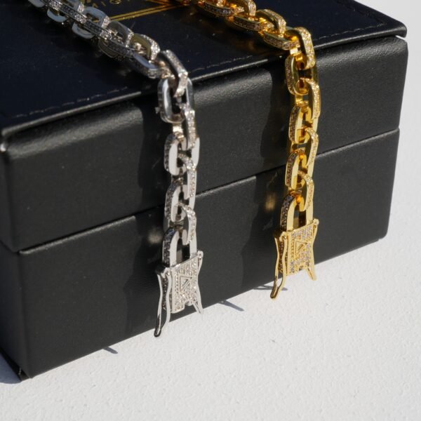 Gold and silver gridlock bracelets with pavé stone detail against black box