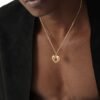 Gold plated skull heart pendant on fine chain necklace with black blazer styling