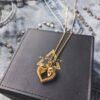 Gold plated skull heart pendant on branded jewelry box with denim background