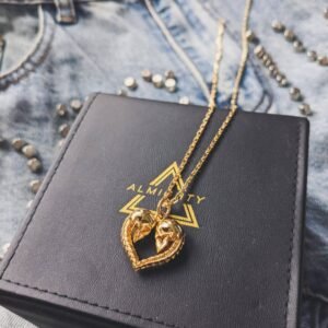 Gold plated skull heart pendant on branded jewelry box with denim background