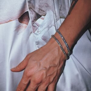 Dual 4mm tennis bracelets in gold and rhodium plating worn with white satin shirt