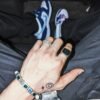 Silver and white gold rings with gem bracelet styled with sneakers and casual wear, hand tattoo detail