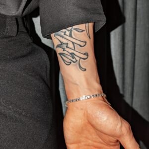 Gold plated tennis bracelet styled with black shirt and tattoo detail